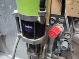 une photo d'une machine verte et noire dans un garage