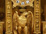 a gold clock that is on display in a room
