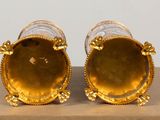 pair of gold plated vases on display on a table