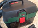 a black and green blow dryer sitting on the floor