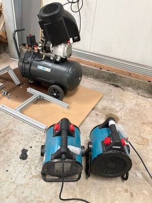 two air compressors sitting on the floor next to each other