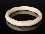 an image of a white bracelet on a black surface