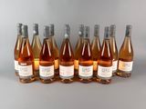 six bouteilles de vin sont alignées sur une surface grise