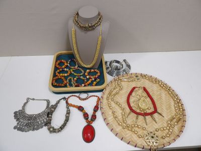 une table sur laquelle sont posés un chapeau, des colliers et d'autres objets