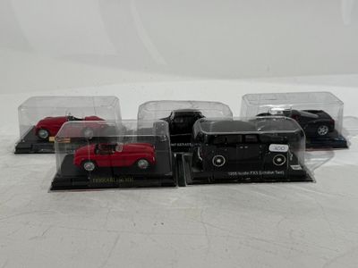 three toy cars in a display case on a white surface