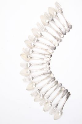 un grand nombre de cuillères et de fourchettes en argent disposées en cercle
