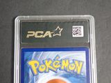 a pokemon card in a plastic case on a table