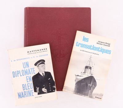 two books are sitting on a table next to a red book
