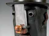 sculpture représentant un homme coiffé d'un haut-de-forme, un couteau dans la bouche
