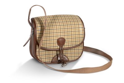 le sac à carreaux marron et beige est muni d'une poignée en cuir