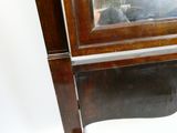 une vitrine en bois surmontée d'un miroir