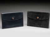 two black and brown leather wallets sitting side by side