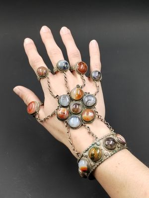 une image représentant la main d'une femme portant un bracelet à maillons et d'autres bracelets