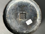 a small metal bowl with a sticker on it
