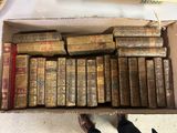 une boîte ouverte remplie de vieux livres, posée sur une table