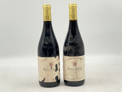 deux bouteilles de vin rouge posées l'une à côté de l'autre sur une surface blanche