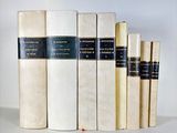 several books are lined up in a row on a white surface