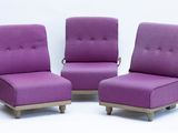 trois chaises violettes placées côte à côte sur une surface blanche