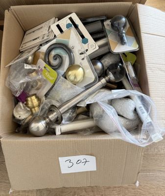 une boîte en carton remplie d'objets hétéroclites sur le sol
