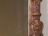 a mirror that is sitting on a shelf next to a vase