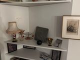 a corner of a room with a book shelf and pictures on the wall