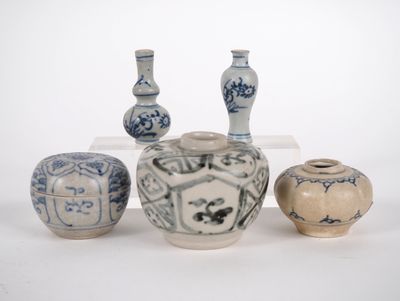 trois vases et deux bocaux posés sur une surface blanche