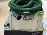 un tuyau vert posé sur un chariot au sol