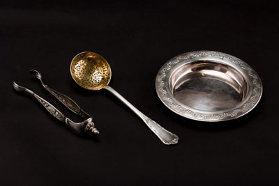 a silver plate with a spoon and a spoon rest next to it