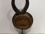 an image of a wooden sculpture of a face on a stand