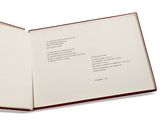 an open book on a white surface with a red border