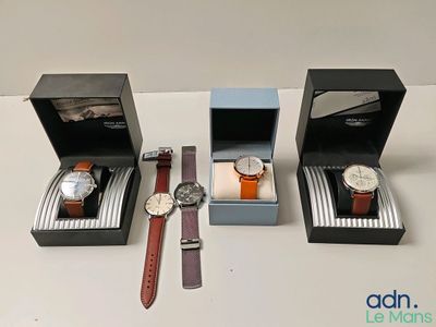 trois montres sont posées dans une boîte noire sur une table