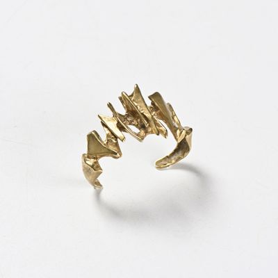 gros plan d'une bague en or sur une surface blanche