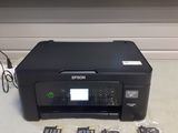 a printer sitting on a counter with a lot of other items