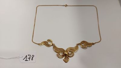 un gros plan d'un collier en or exposé sur une table