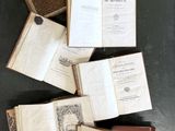 de nombreux livres ouverts posés sur une table, sur fond noir