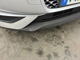 the front end of a silver car with a number plate on it