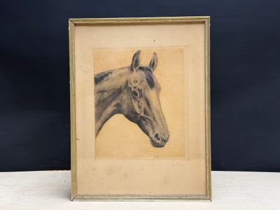 an old picture of a horse in a frame on a table