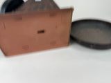 a brown box with a black lid next to a brown pan