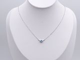 a white mannequin with a necklace and a blue topaz stone on it