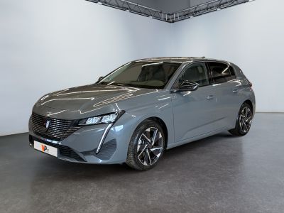 a grey car is parked in a large room with a white wall