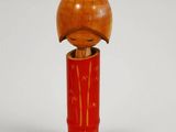 une petite figurine en bois surmontée d'une pomme