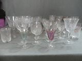 many wine glasses sitting on a table next to each other