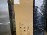 a large box sitting next to a refrigerator in a warehouse