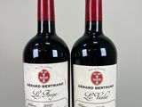 two bottles of red wine sitting next to each other on a table