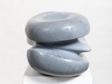 a stack of rocks sitting on top of a white pedestal