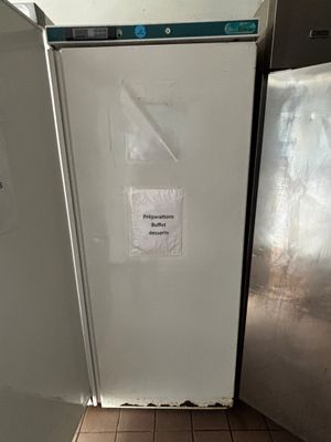 un réfrigérateur sur lequel est accrochée une affiche, dans la cuisine