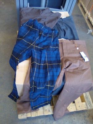 une pile de vêtements posée sur une palette dans un entrepôt