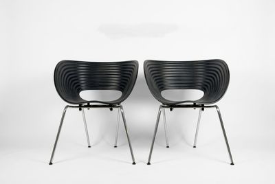 two black chairs sitting next to each other on a white surface