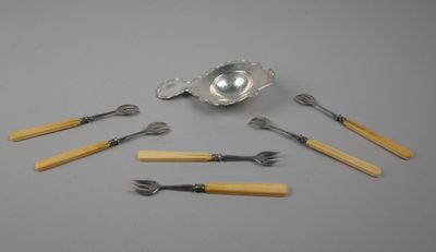 une cuillère, une fourchette et un repose-cuillère en argent posés sur une table