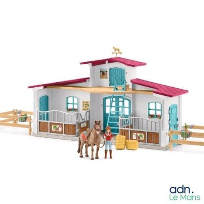 a horse stable with a horse and two horses in front of it